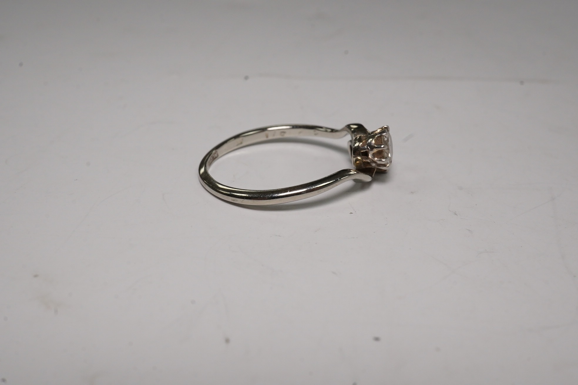 An 18ct, plat and two stone diamond set crossover ring, size O, gross weight 2.3 grams, Condition - fair to good